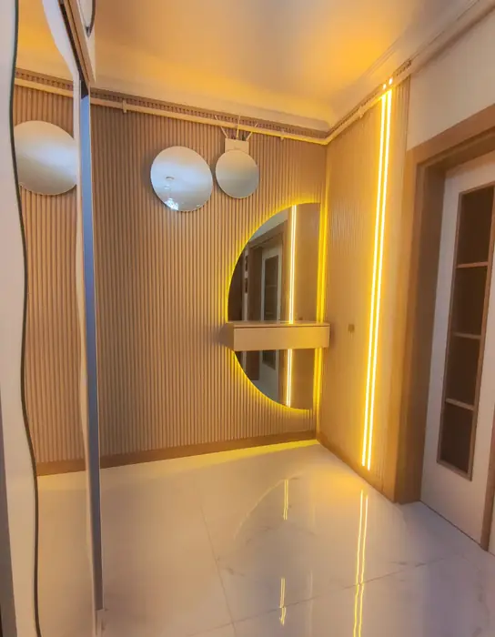 Dekoratif hol duvarı — kavisli aynalı panel ve gizli ışık
