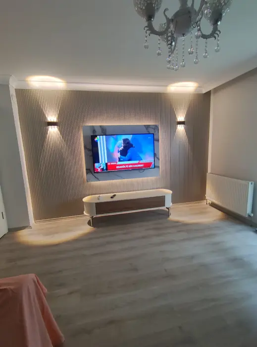 Salon — aplik aydınlatmalı TV duvarı ve gizli ışık